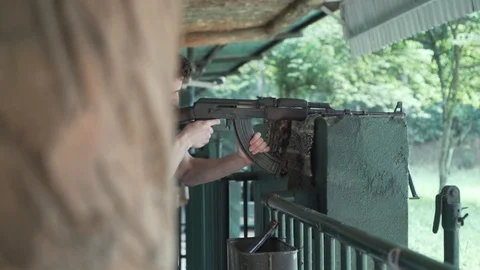 Millennial white man fires ak 47 assault rifle then laughs enthusiastically Stock Footage 87263509