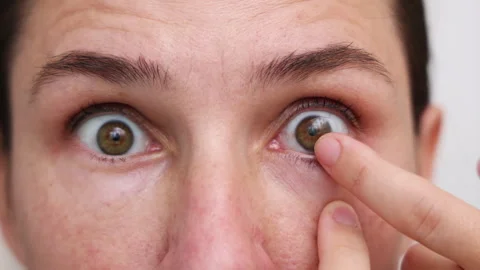 Millennial woman put or remove contact lens Stock Footage 247173423
