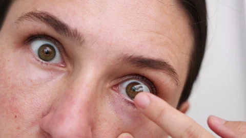 Millennial woman put or remove contact lens Stock Footage 247173550