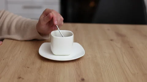 Millennial woman sitting in kitchen drinking coffee using smartphone Stock Footage 239302829