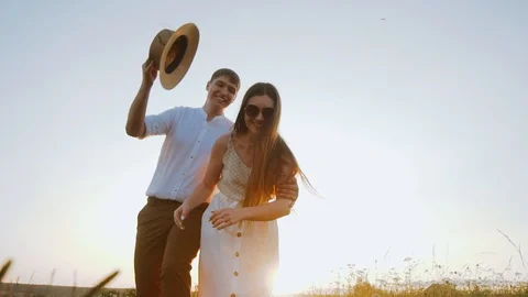 Millennials couple have fun playing with hat, running and catching each other. Stock Footage 122559828