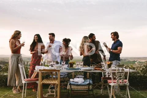 Millennials enjoying dinner party outdoors Stock Photos