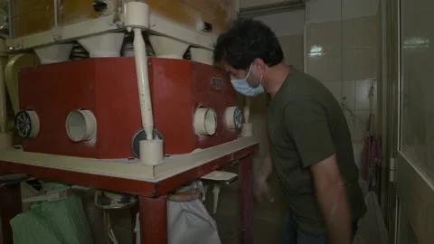 A miller checking the operation of a mechanical industrial mill and working Stock Footage 173501840