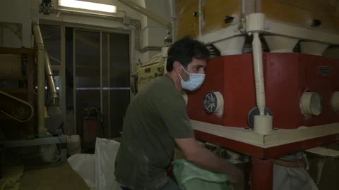 A miller checking the operation of a mechanical industrial mill and working Stock Footage 173501984