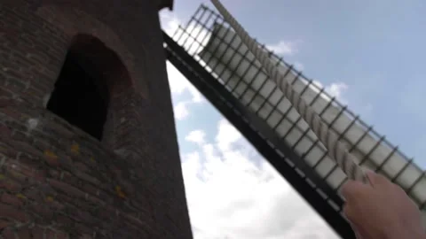 A miller pulls a rope to control the blades of a windmill Stock Footage 154757427