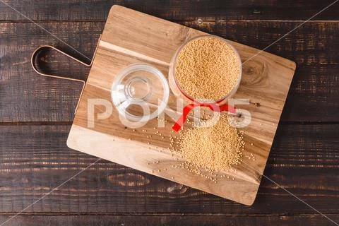 Millet in glass jar on wooden background Stock Photos
