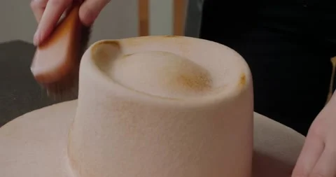 Milliner brushes felt hat to remove burnt fine fur fibers Stock Footage 207455620