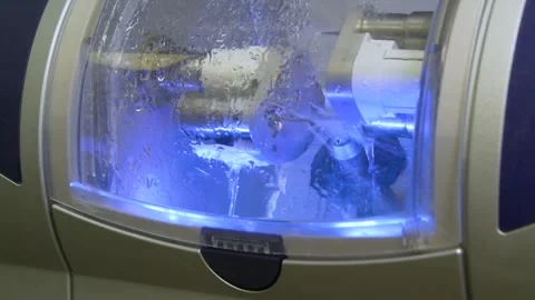 The milling machine cuts the ceramic dental crown from the workpiece. Stock Footage 256581220