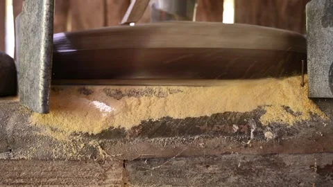 A millstone is spinning. A stone grinds grain in a mill. Corn flour. Stock Footage 272354971