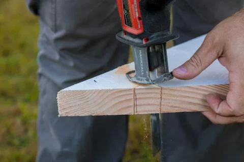 Milwaukee power tools Man using cuts wood electric jigsaws close up Stock Photos
