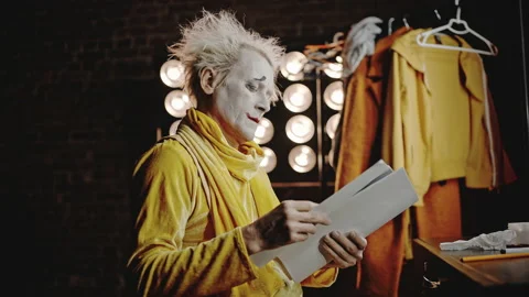 Mime in costume opens script underlining lines with pencil Stock Footage 192397880