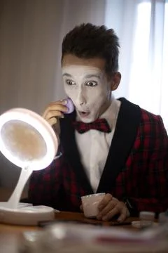 Mime guy puts makeup before the performance Foto stock
