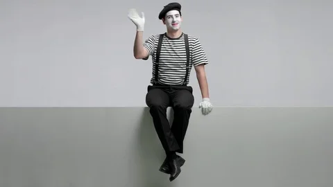 Mime sitting on a panel and waving at the camera Vidéo 77203136