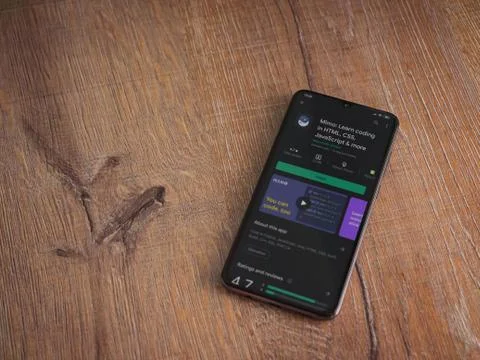 Mimo - Learning coding app play store page on the display of a black mobile s Fotos de archivo