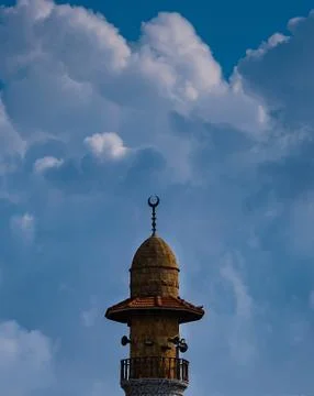Minaret of the mosque on the background of the cloudy sky Stock Photos