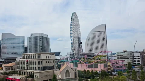 Minato Mirai skyline featuring the Cosmo Clock 21 Ferris wheel spinning in an Stock Footage 328385732