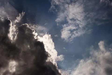 Minatory clouds of a thunderstorm with bright sun Stock Photos