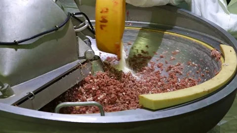 The minced meat is automatically stirred in a large bowl. A food additive is pou Stock Footage 129305918