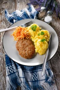 Minced meat cutlet served with mashed potatoes and carrot salad. Stock Photos
