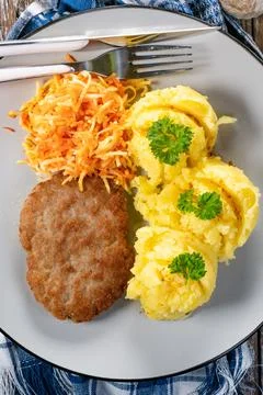 Minced meat cutlet served with mashed potatoes and carrot salad. Stock Photos