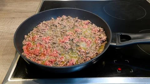 Minced meat in a pan. Frying process. Stock Photos