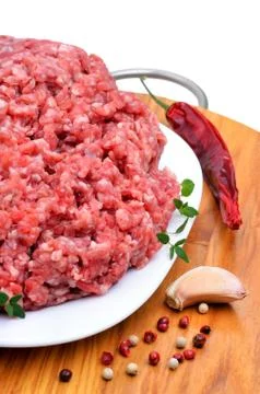 Minced meat with pepper, thyme and garlic on cutting board isolated on white Stock Photos