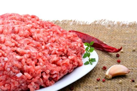 Minced meat with pepper, thyme and garlic on sacking background Stock Photos