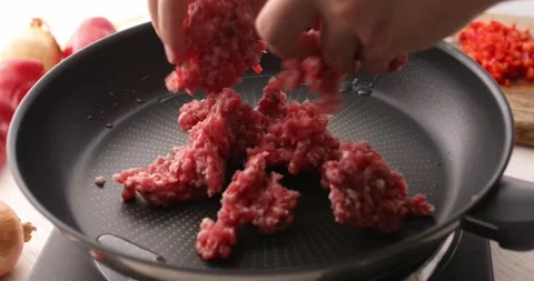 Minced meat is placed in a heated pan. Stock Footage 249663225
