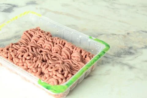 Minced meat in a plastic tray. Packaged industrial food Stock Photos
