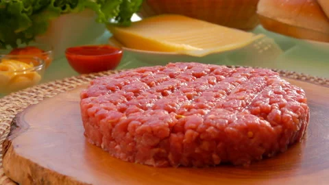 Minced meat pressed into a cutlet is laying on the wooden board Stock Footage 127644350