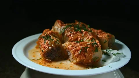 Minced meat stew in cabbage leaves, in the form and on a plate, play with light Stock Footage 153802233