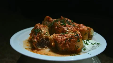 Minced meat stew in cabbage leaves, in the form and on a plate, play with light Stock Footage 153802298