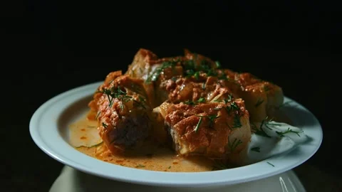 Minced meat stew in cabbage leaves, in the form and on a plate, play with light Vídeos de archivo 153802306