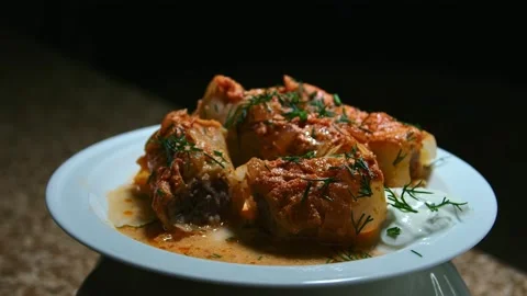 Minced meat stew in cabbage leaves, in the form and on a plate, play with light Stock Footage 153802321