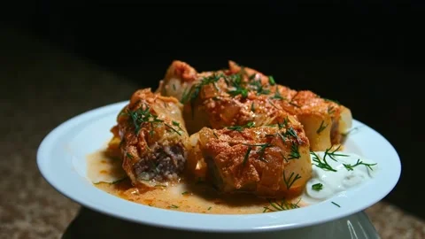 Minced meat stew in cabbage leaves, in the form and on a plate, play with light Stock Footage 153802335