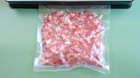 Minced meat in a vacuum bag on a green background close-up. Stock Footage 281149531
