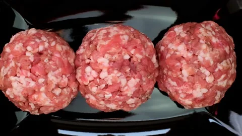 Minced pork. Round balls of minced pork on a black slate background Stock Footage 144065597