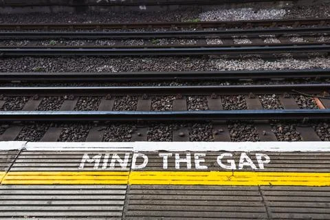 Mind the Gap sign on a train platform warning passengers to be cautious while Stock Photos