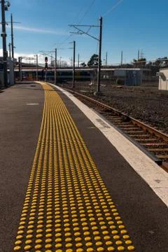 The mind gap warning on a platform at a train station, with yellow studs for  Stock Photos