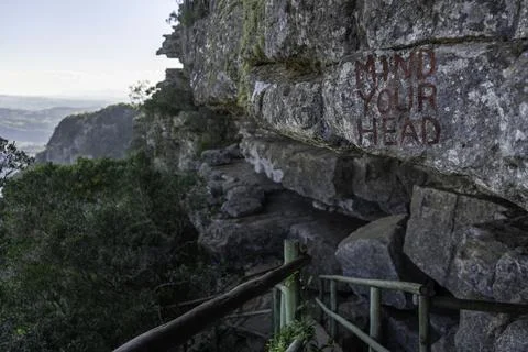 Mind Your Head painted on over-hanging rock found on steep hike in Oribi Gorge Stock Photos