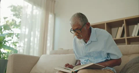 Mindful elderly Asian man in glasses reading a book for lifelong learning Stock Footage 336057854