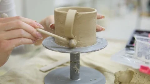 Mindful pottery making as hands gently shape a clay mug, carefully attaching the Stock Footage 303140988