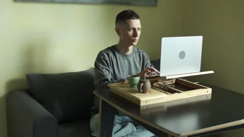 Mindful remote work with tea set and laptop in realistic home scene. Stock Footage 316627484