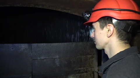 Miner go down into a mine shaft in the elevator cage, silhouette in darkness Stock Footage 94122622