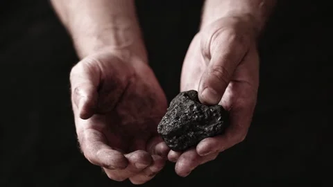 A miner shows the pieces and nuggets of coal in his hands. Stock Footage 201656185