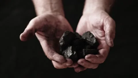 A miner shows the pieces and nuggets of coal in his hands. Stock Footage 201895474