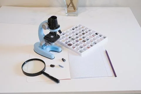 Mineral collection study with microscope and magnifying glass on desk. educ.. Fotos de archivo