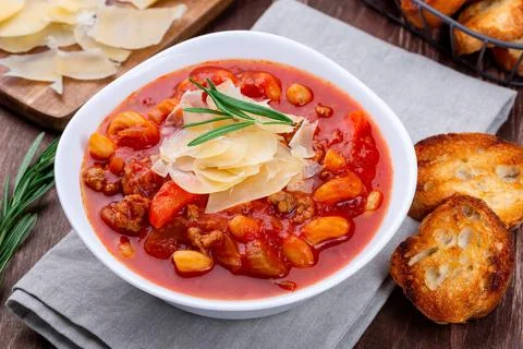 Minestrone soup served with crispy bread, on wooden background, horizontal Foto stock