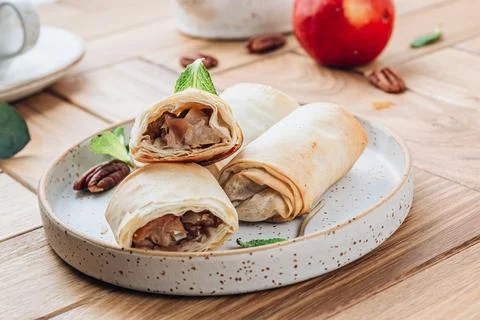 Mini apple strudel with pecans and mint on wooden table. Viennese pastry. Stock Photos