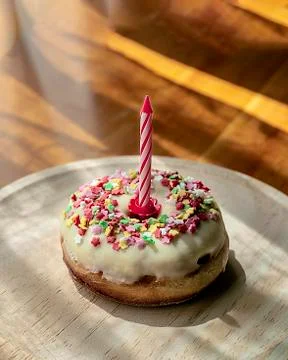 Mini artisan cake in the shape of white chocolate donuts with colored topping Stock-Fotos